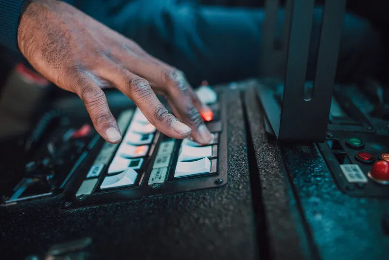 A hand adjusting controls on an industrial control panel