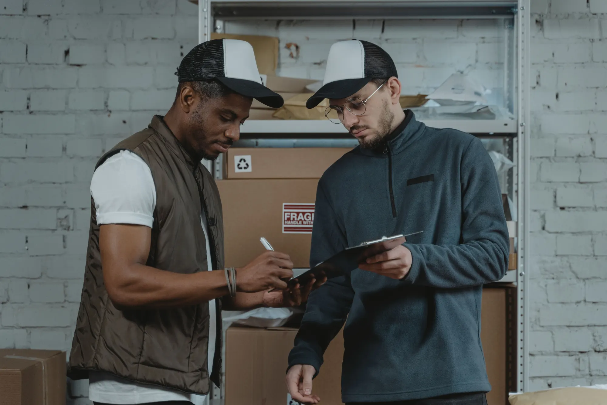 A worker signing off on a clipboard in a warehouse setting.